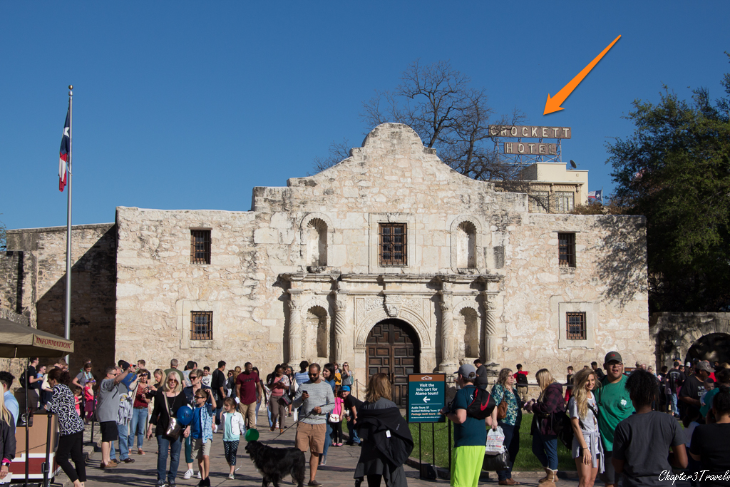 Large hotel sign directly behind the Alamo.