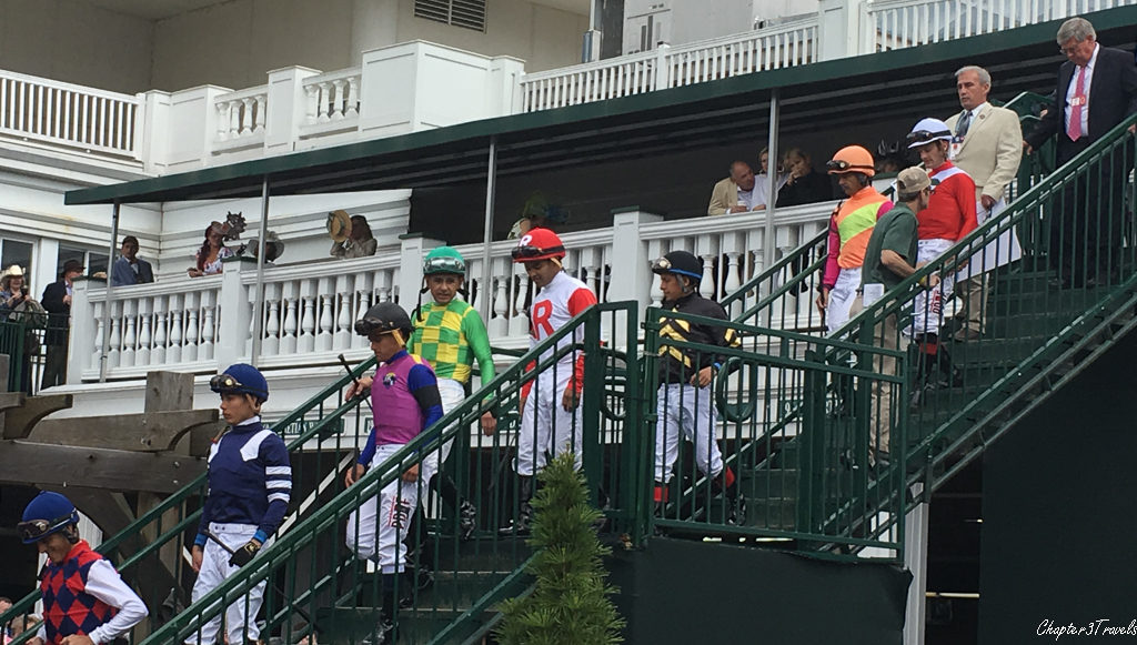 Eight jockeys walking down a staircase at Churchill Downs