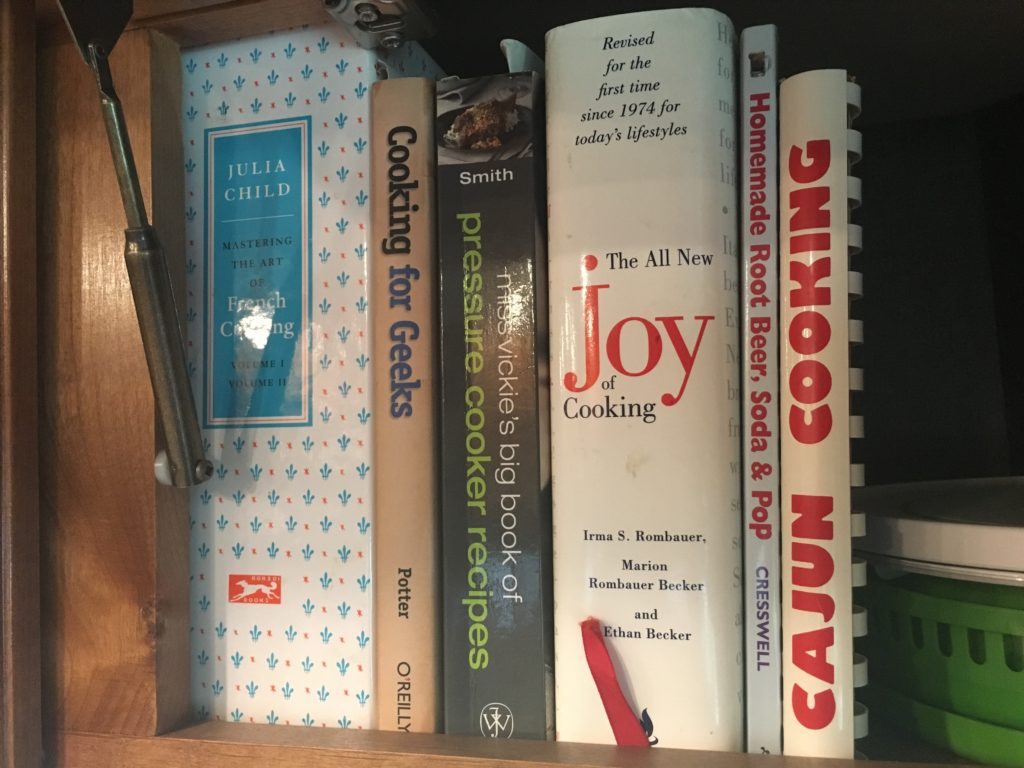 Cabinet shelf with cook books.