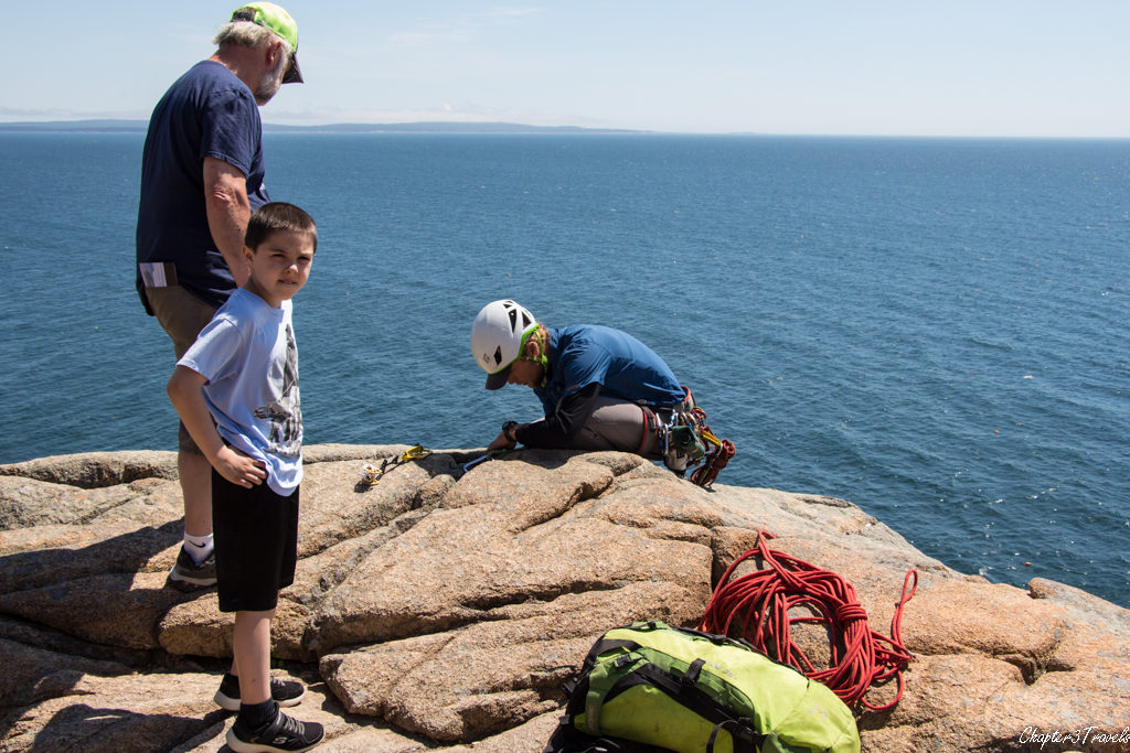 Tourist talking to rock climber on top of Otter Cliffs
