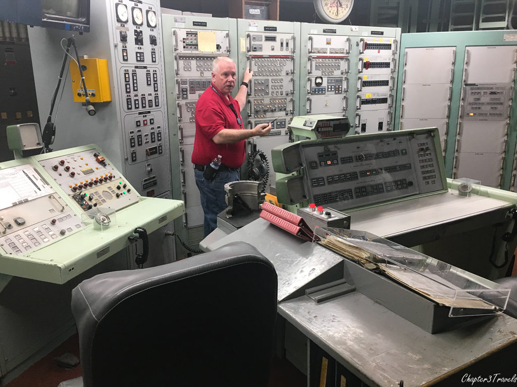 Tour guide pointing to butterfly valve lock in command and control room at Titan Missile Museum