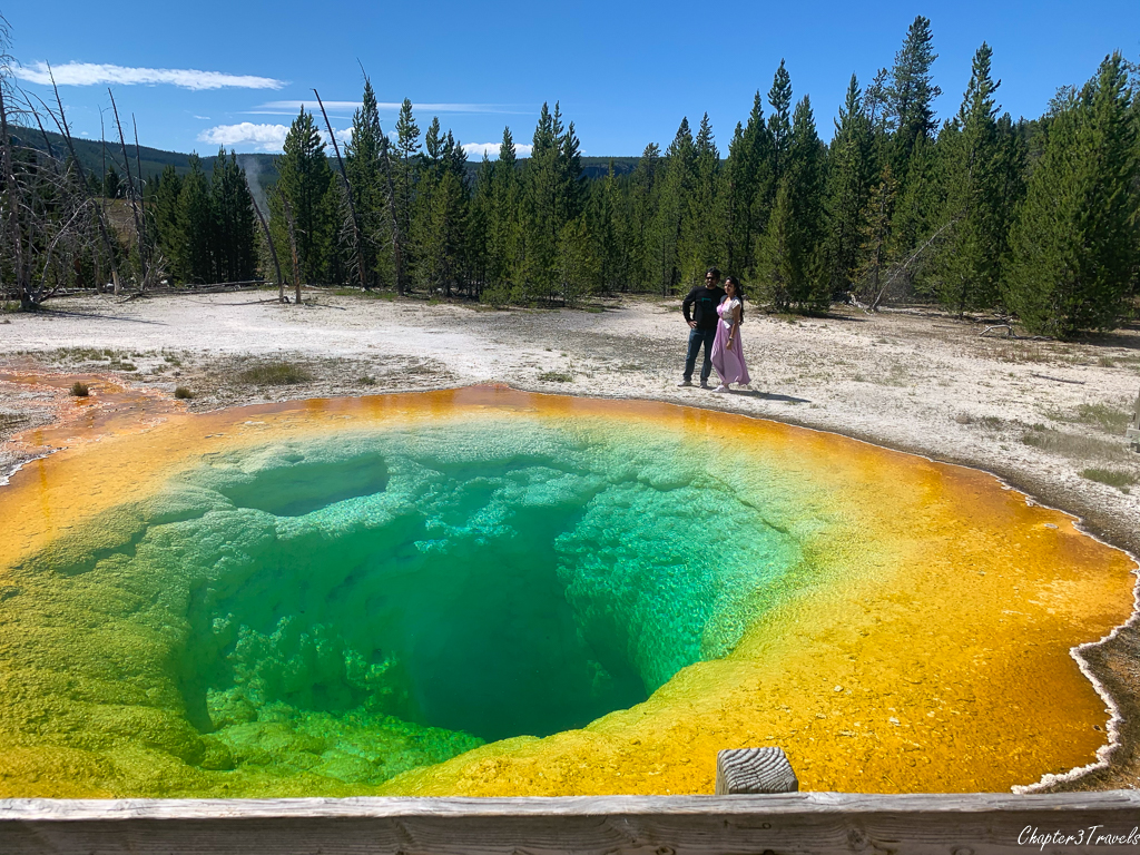 Tourists standing on the ground behind Morning Glory Pool