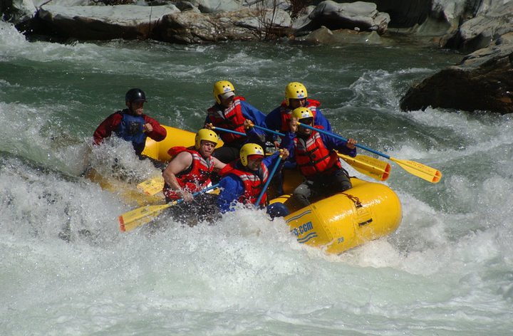 six people in raft paddling whitewater