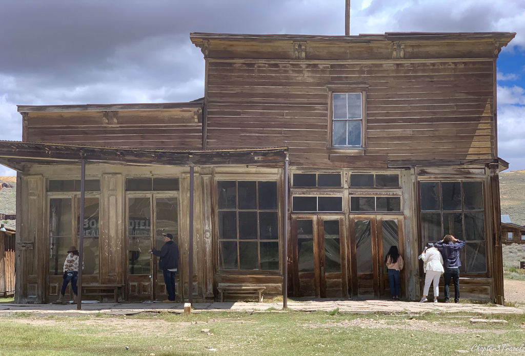 Tourists peering into the windows of a building in Bodie State Historic Park